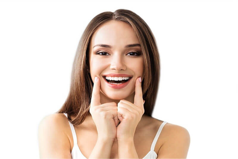 Picture of a smiling woman with long brown hair, facing the camera and, happy with her dental all-on-four she received from Premier Holistic Dental in Costa Rica.